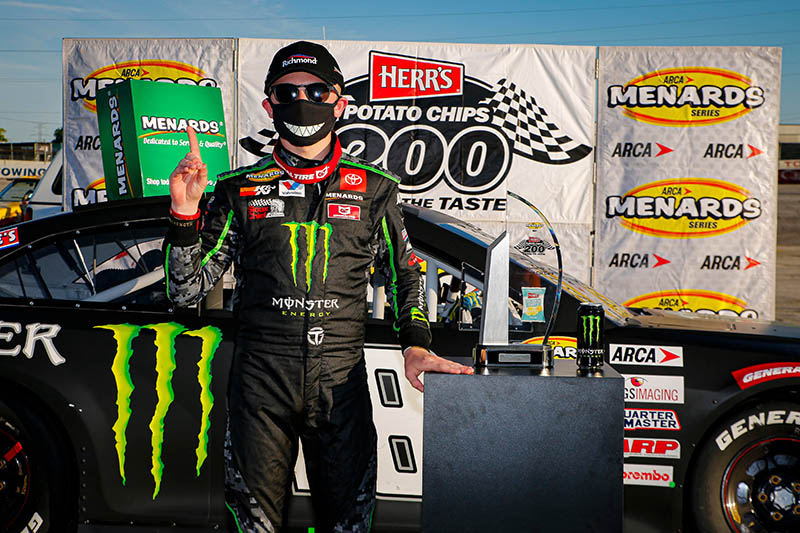 Ty Gibbs Herr's Potato Chips 200 victory photo with his race car behind him.